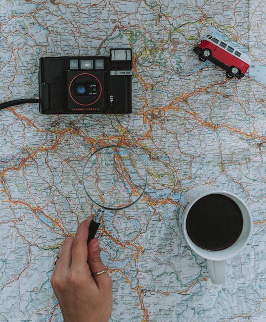 Person Using Magnifying Glass On A Map